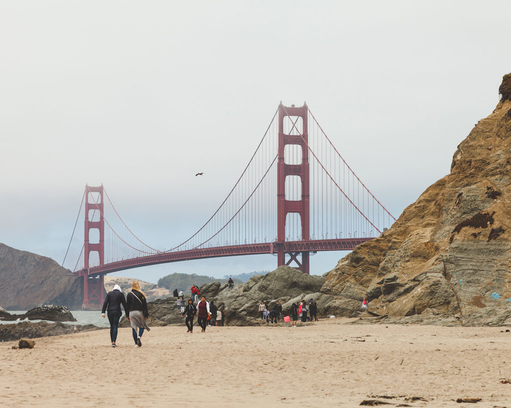 Visitors at Baker Beach with Golden Gate Bridge in the background