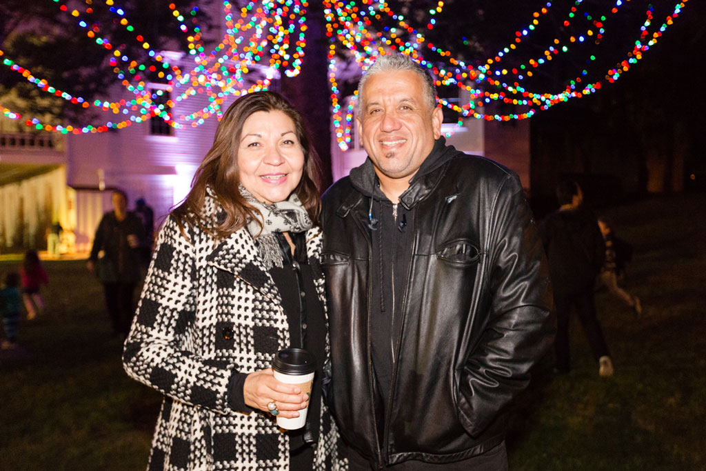 Man and woman in front of tree with lights