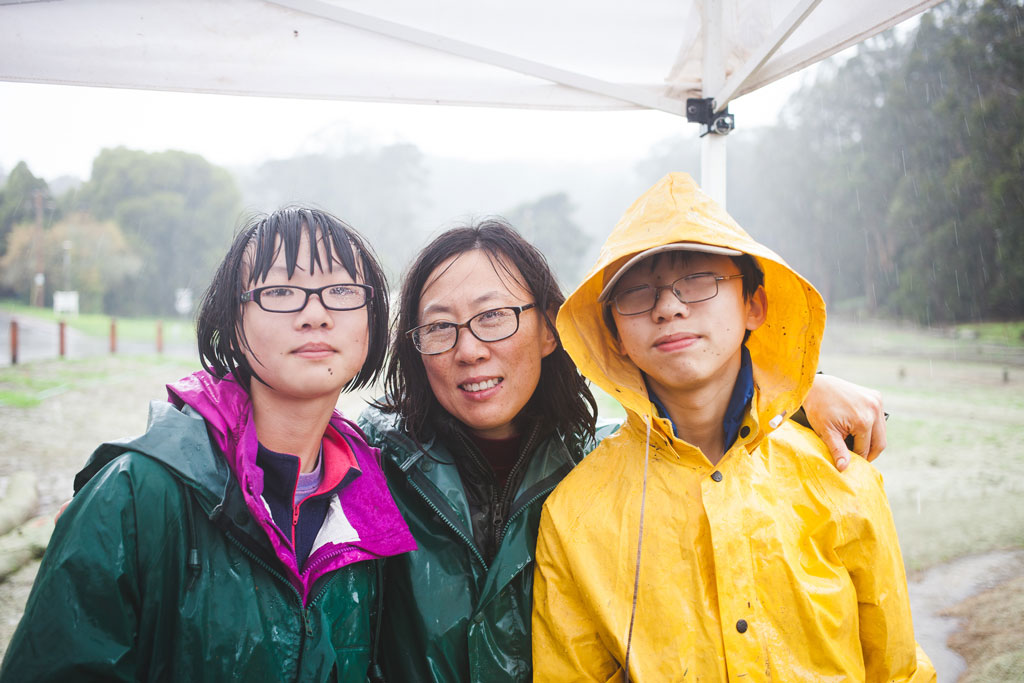 A couple women and young man in rain jackets