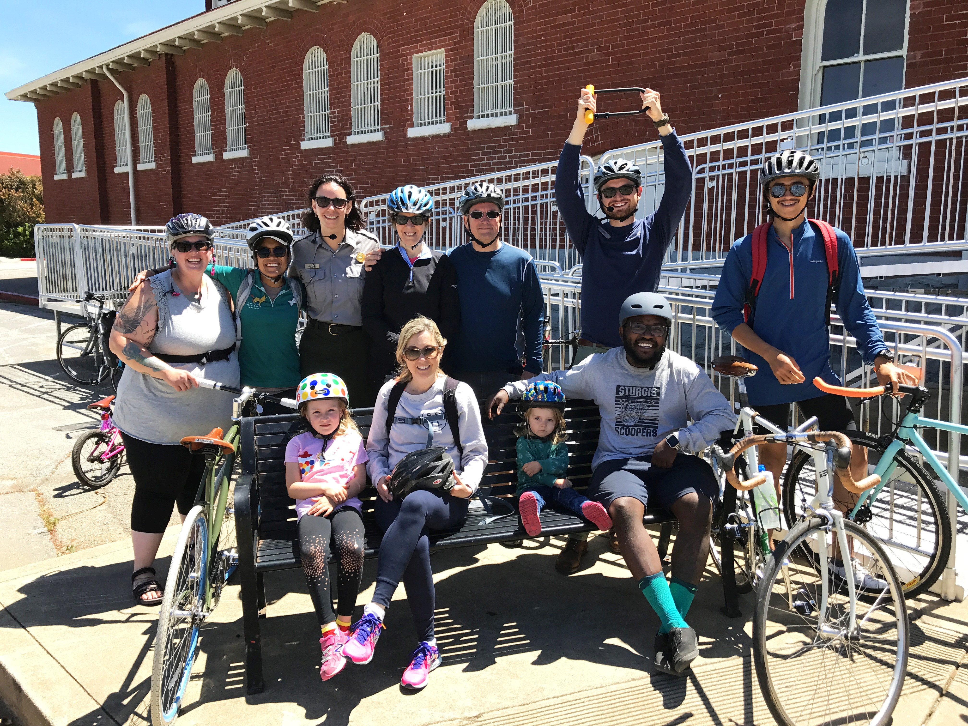 Group of people sitting outside of the Visitor Center with their bikes.