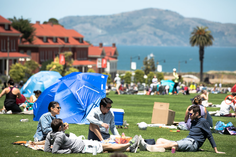 Parkgoers on Main Parade Lawn on a sunny day.