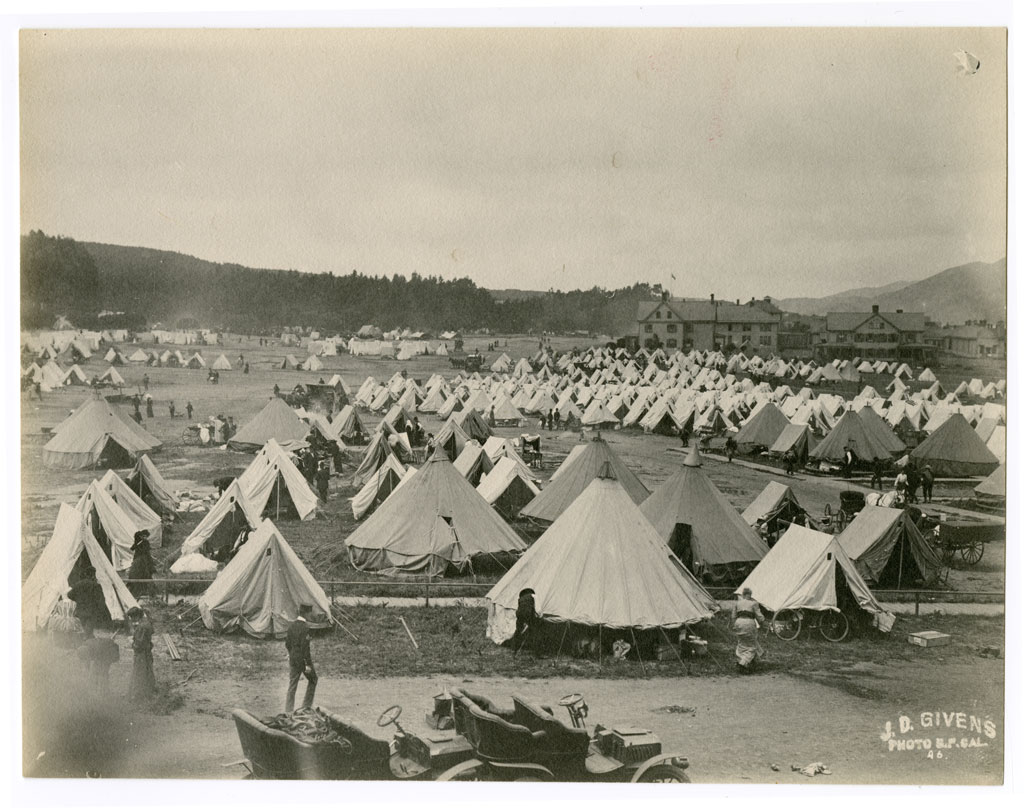 Tents in earthquake refugee camp. Hospital buildings visible to rear right.