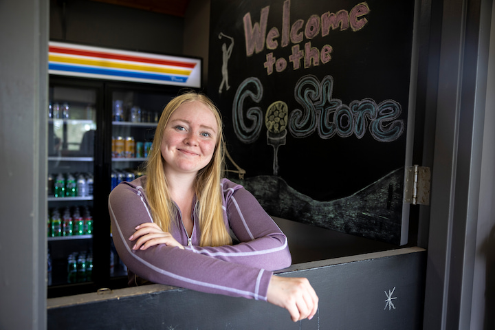 Woman working inside the Golf Course General Store.