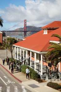 Presidio Visitor Center exterior, with the Golden Gate Bridge in the background.