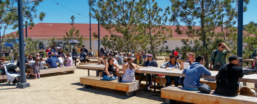 A group of people sitting at tables at Picnic Place. Photo by Dan Friedman.