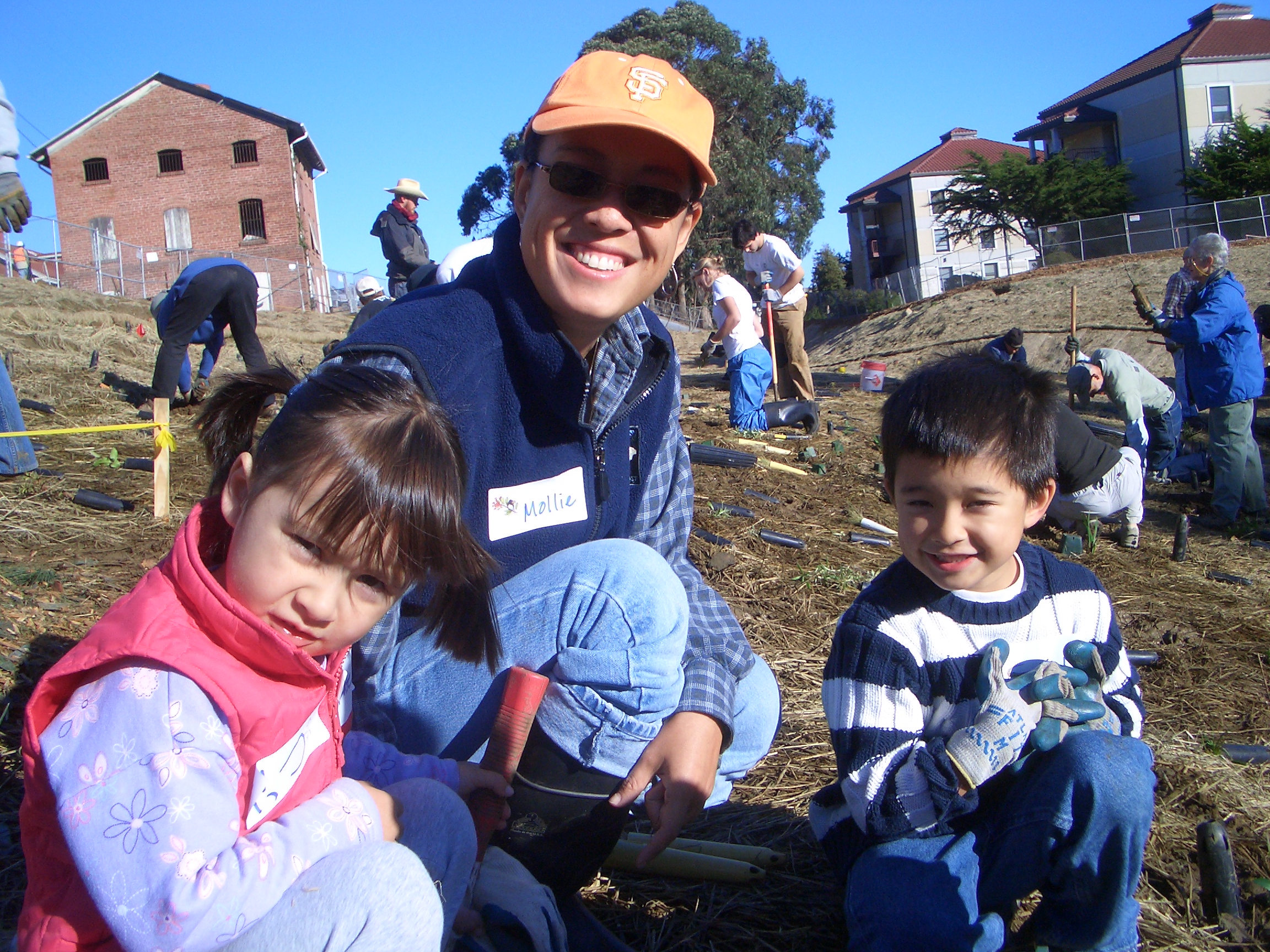 Woman volunteering with her two young children.