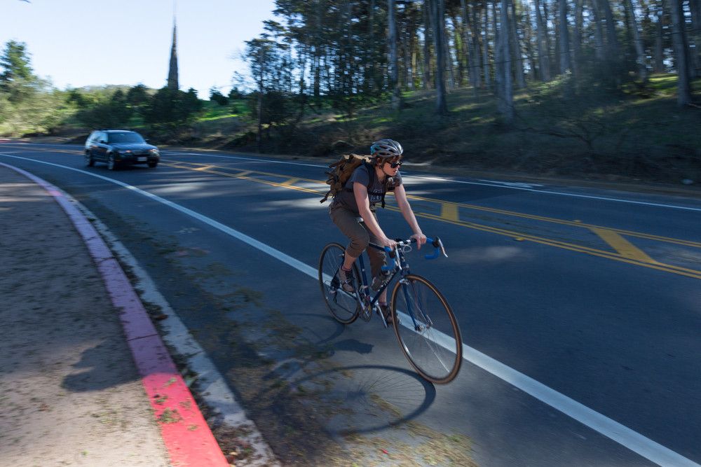 Man riding a bike on Arguello Boulevard with Spire in the background.