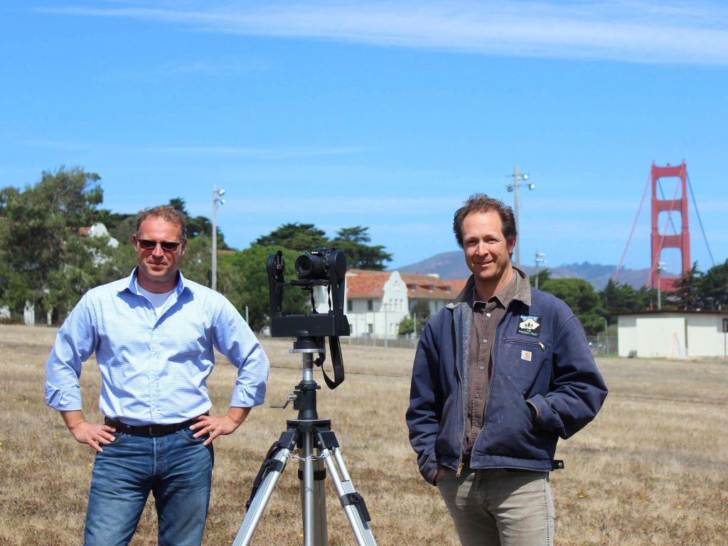 Hans Barnaal and Lew Stringer at Fort Scott with camera and bridge in background.