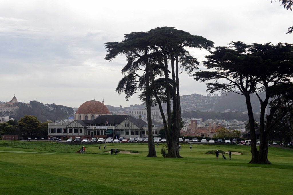 A grey day at the golf course with people playing golf.