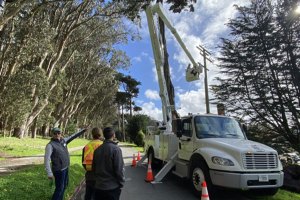 Three Presidio Trust staff members underground a power line.